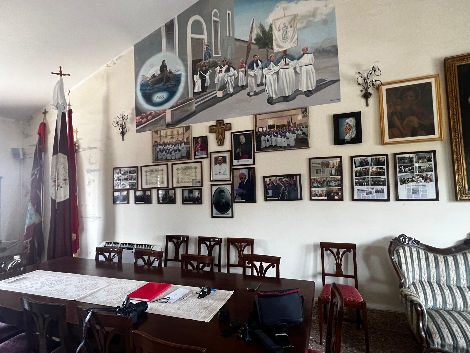 La sala della sede della Confraternita, con il murale e le fotografie storiche