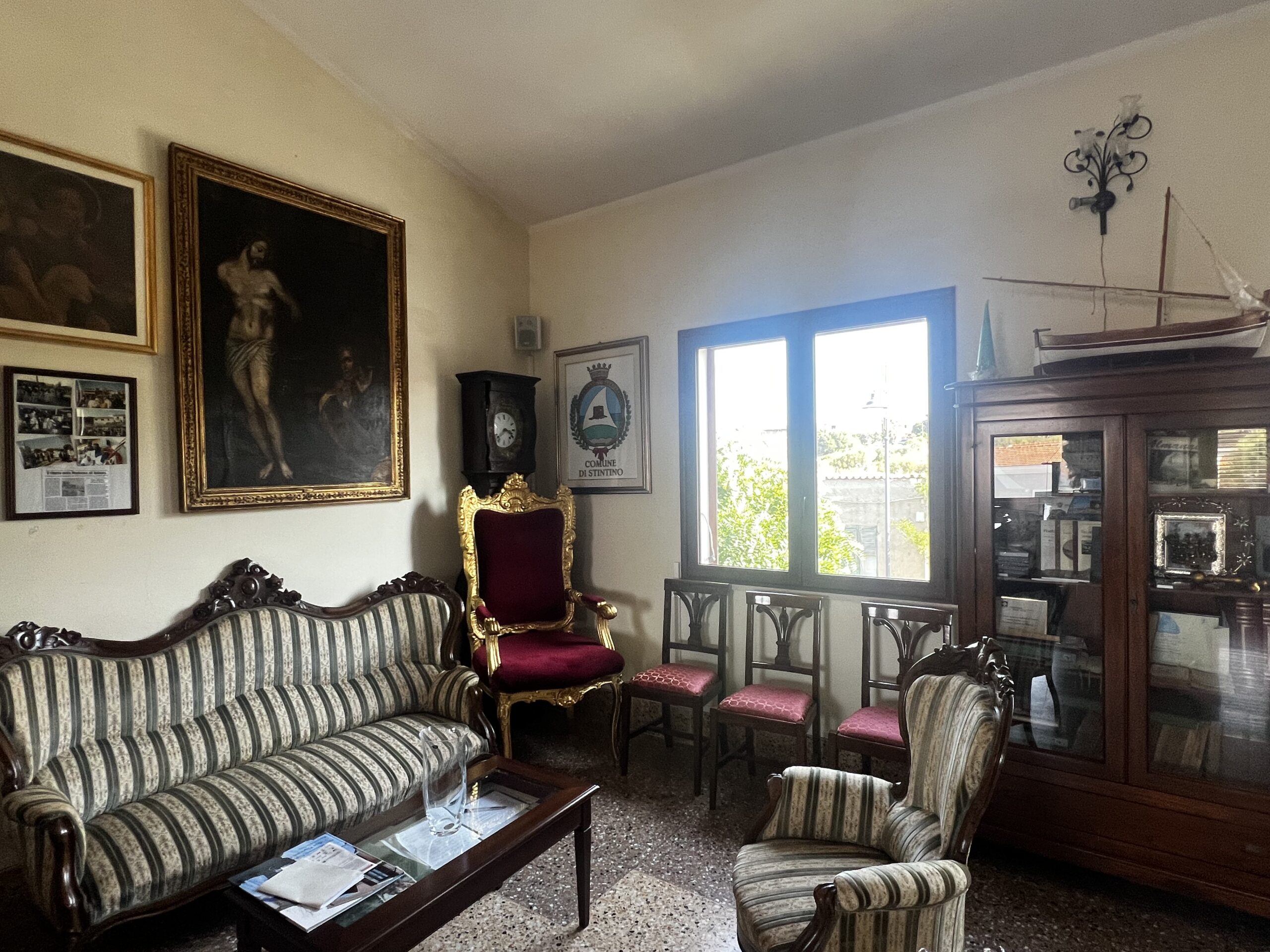 Salotto d'epoca nella sede della Confraternita con poltrona dorata e stemma del Comune di Stintino