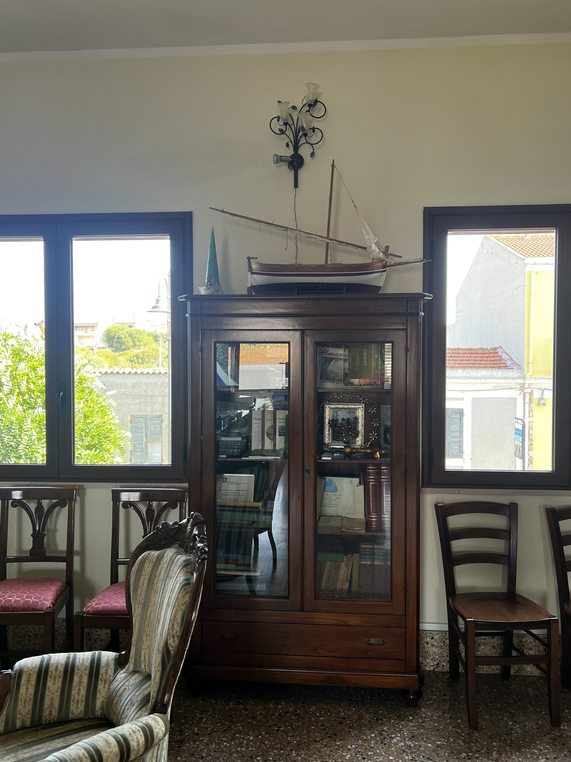 Sala della sede con vetrina d'epoca, poltrone e modellino di veliero