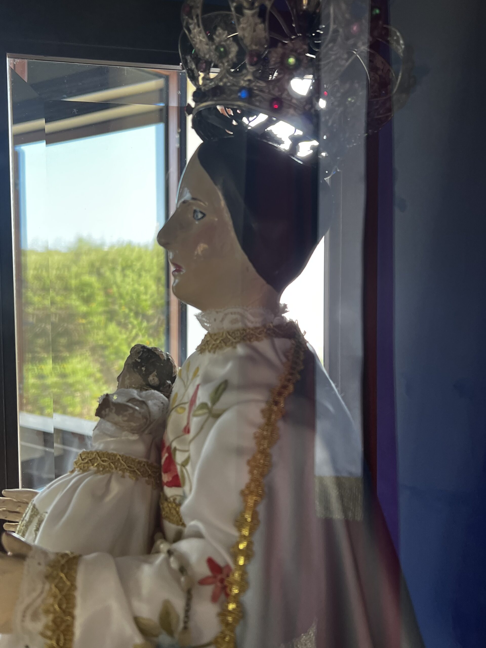 Statua della Madonna della Difesa vista di profilo, con corona e Bambino in braccio
